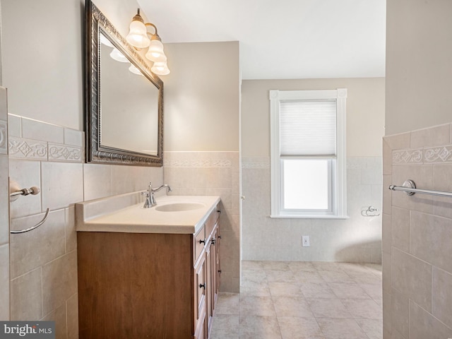 bathroom featuring tile patterned flooring, vanity, and tile walls