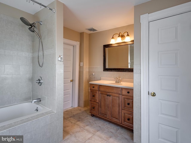 bathroom featuring vanity and tiled shower / bath combo