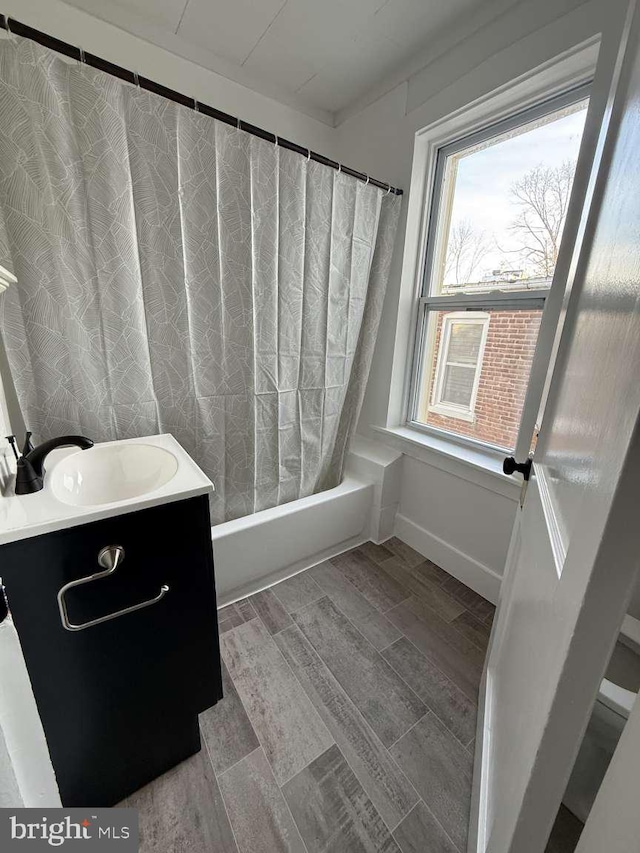 bathroom with hardwood / wood-style floors, vanity, and shower / tub combo