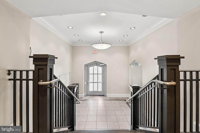 foyer with light tile patterned floors and ornamental molding