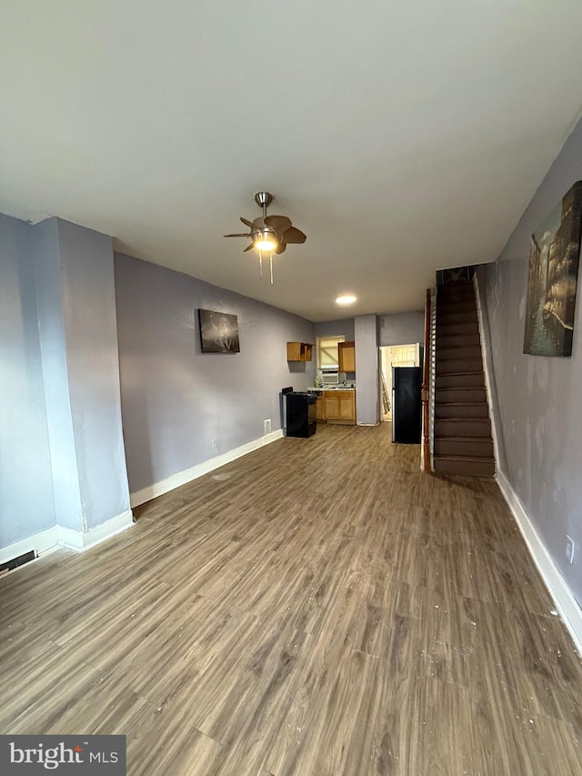 unfurnished living room featuring ceiling fan, vaulted ceiling, and hardwood / wood-style flooring