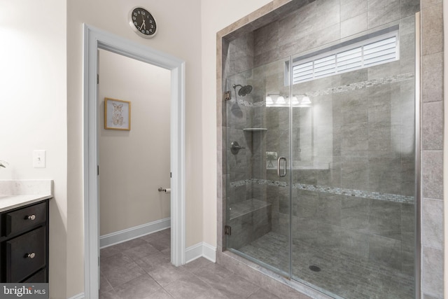 bathroom with a shower with door, vanity, and tile patterned flooring