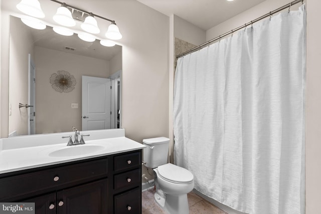 bathroom with tile patterned flooring, vanity, and toilet