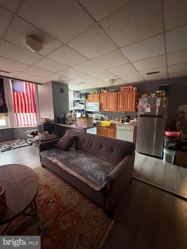 living room featuring a drop ceiling, wood finished floors, and visible vents