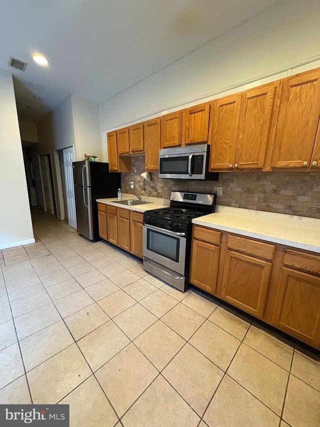 kitchen with light tile patterned floors, visible vents, appliances with stainless steel finishes, light countertops, and a sink