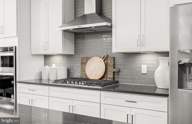 kitchen featuring white cabinets, wall chimney exhaust hood, and appliances with stainless steel finishes