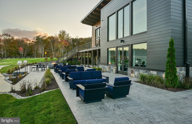 patio terrace at dusk with an outdoor hangout area and a yard