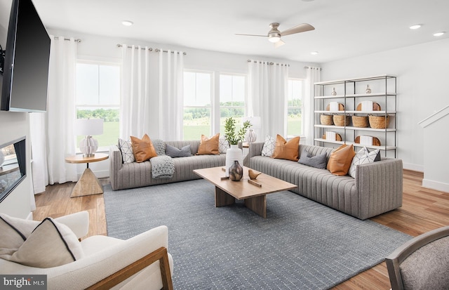 living room with ceiling fan and light hardwood / wood-style floors