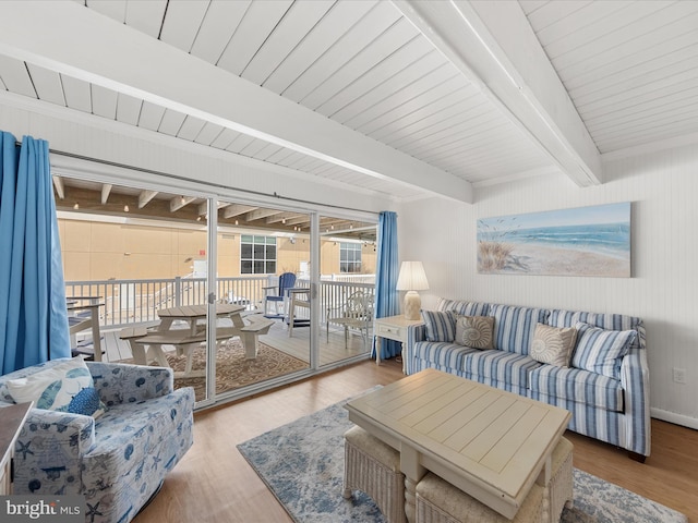 living room with beamed ceiling and wood finished floors