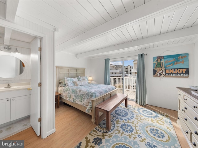 bedroom featuring wooden ceiling, light wood-style flooring, access to exterior, beam ceiling, and a sink