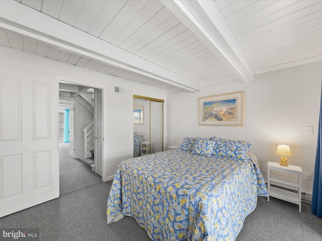 carpeted bedroom featuring a baseboard heating unit, a closet, visible vents, and beamed ceiling