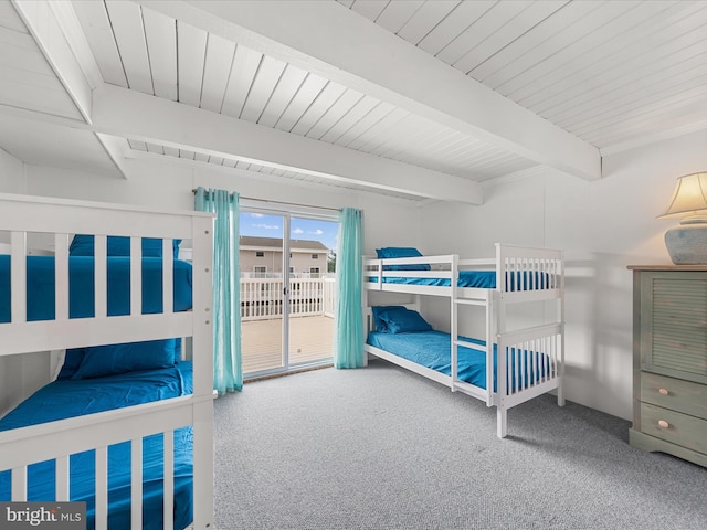 carpeted bedroom featuring access to exterior and beam ceiling