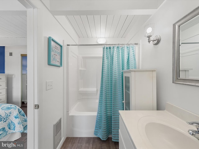 full bathroom with visible vents, wood finished floors, shower / bath combo with shower curtain, and vanity