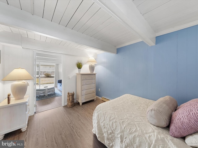 bedroom with wooden ceiling, beam ceiling, a baseboard heating unit, and wood finished floors