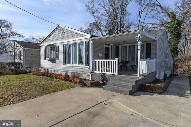 bungalow-style house featuring covered porch and a front yard