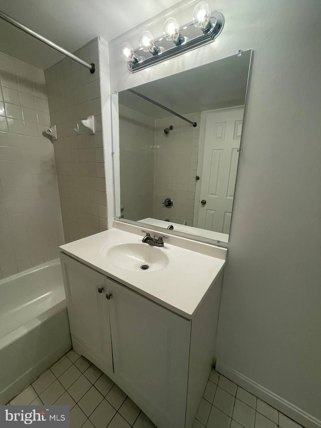 bathroom featuring tile patterned flooring, vanity, and tiled shower / bath