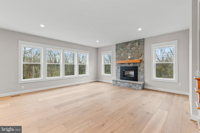 unfurnished living room with a fireplace and light hardwood / wood-style floors