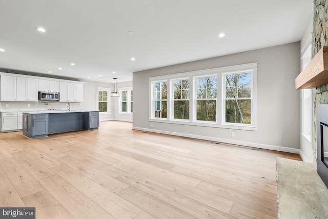 unfurnished living room featuring a fireplace and light hardwood / wood-style flooring