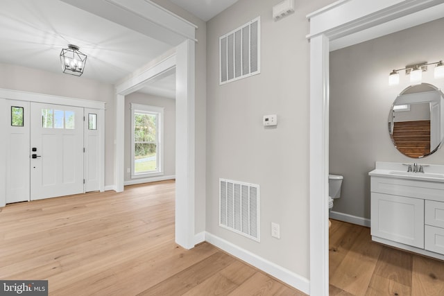 entrance foyer with sink and light hardwood / wood-style flooring