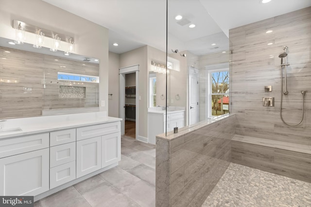 bathroom with vanity and a tile shower