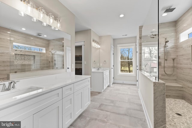 bathroom with vanity and tiled shower