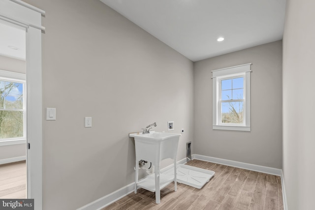 laundry room with electric dryer hookup, washer hookup, and light wood-type flooring