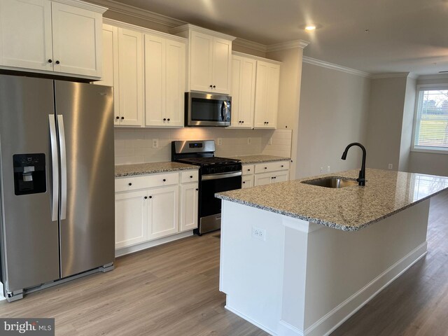 kitchen featuring a kitchen island with sink, sink, white cabinets, and appliances with stainless steel finishes