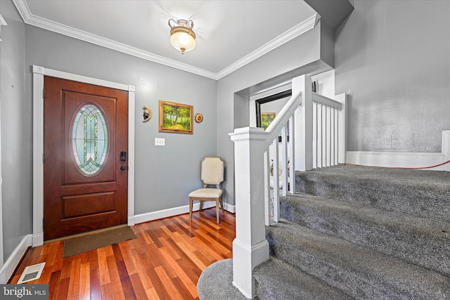 entrance foyer with hardwood / wood-style flooring, a healthy amount of sunlight, and ornamental molding