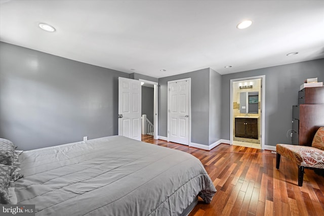 bedroom featuring hardwood / wood-style floors, a closet, and ensuite bath