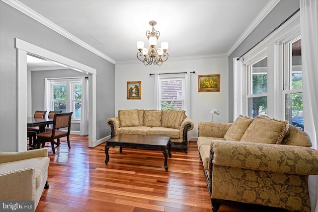 living room featuring crown molding, hardwood / wood-style flooring, and a notable chandelier