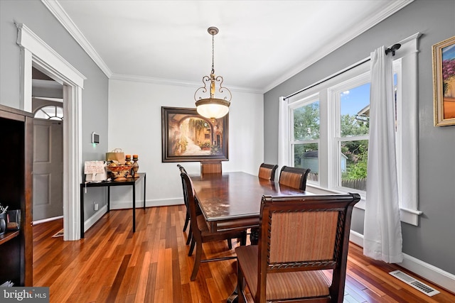 dining area with dark hardwood / wood-style floors and ornamental molding