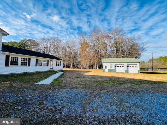 view of yard with a garage and an outbuilding