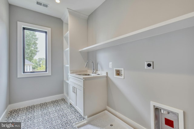 laundry area with cabinets, hookup for a washing machine, electric dryer hookup, sink, and light tile patterned flooring