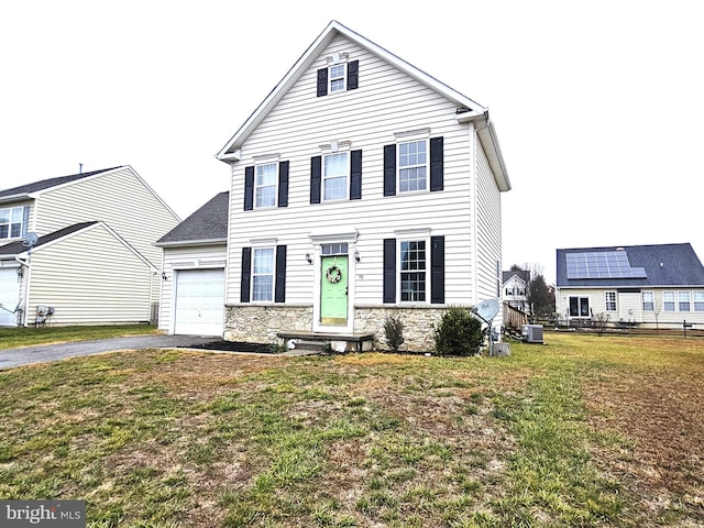 front of property with cooling unit, a garage, and a front yard