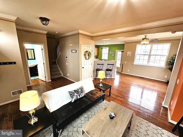 living room with crown molding, hardwood / wood-style floors, and ceiling fan