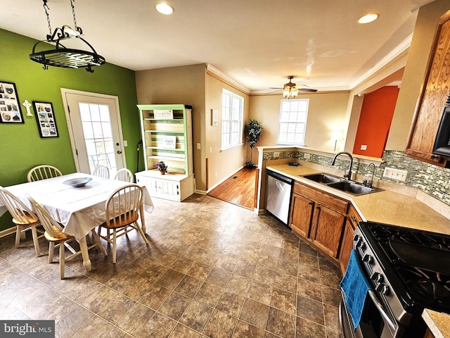 kitchen with pendant lighting, crown molding, sink, ceiling fan, and appliances with stainless steel finishes