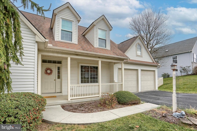 cape cod home with covered porch and a garage