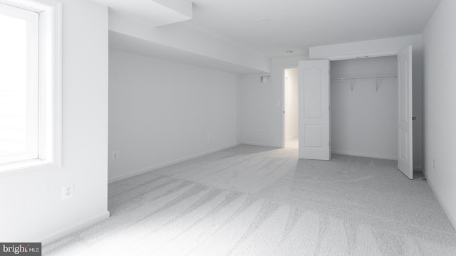 unfurnished bedroom featuring light colored carpet and a closet