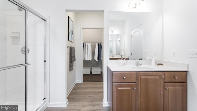 bathroom featuring hardwood / wood-style flooring, vanity, and an enclosed shower