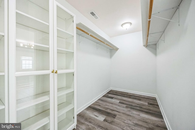 walk in closet with dark hardwood / wood-style flooring