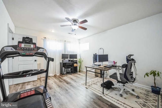 home office with light hardwood / wood-style floors and ceiling fan