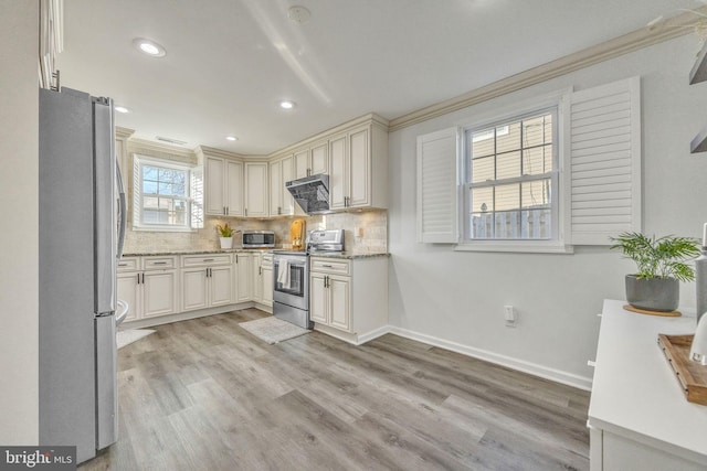 kitchen with light hardwood / wood-style floors, ornamental molding, and stainless steel appliances