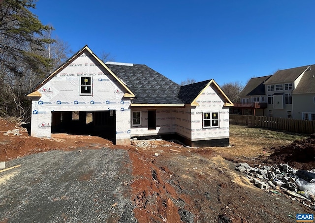 property in mid-construction with a garage, driveway, and fence