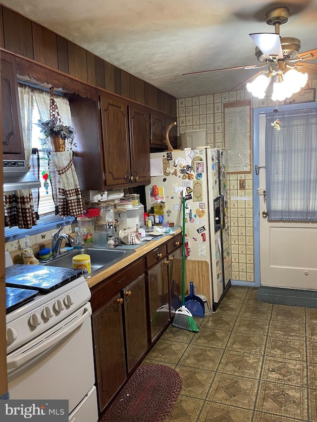 kitchen with white appliances, sink, ceiling fan, a textured ceiling, and dark brown cabinets