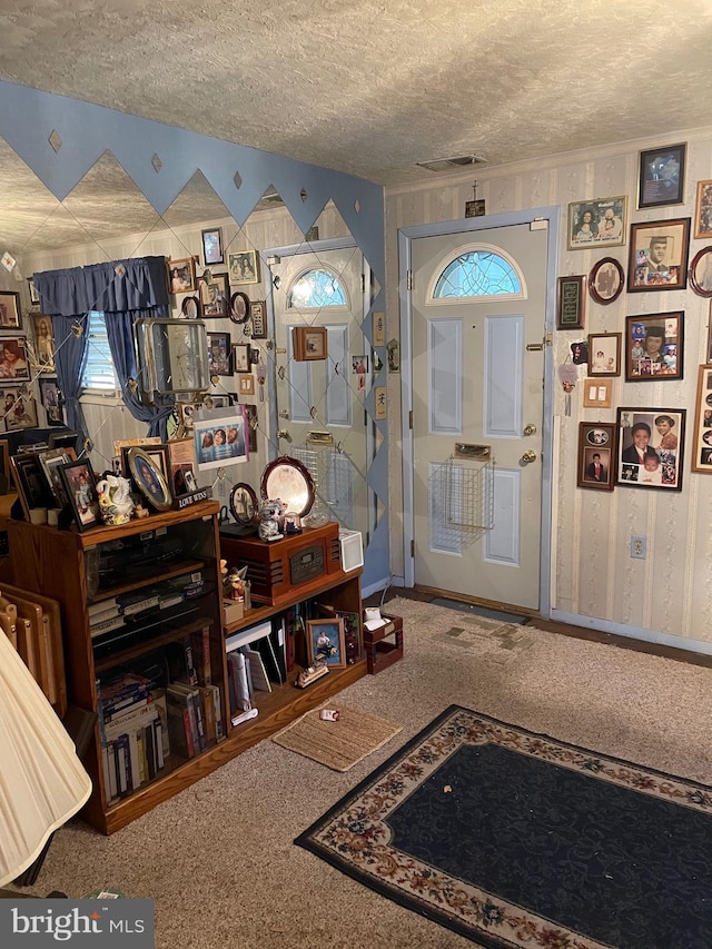 foyer entrance with carpet and a textured ceiling