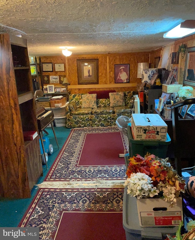 living room featuring a textured ceiling and wood walls