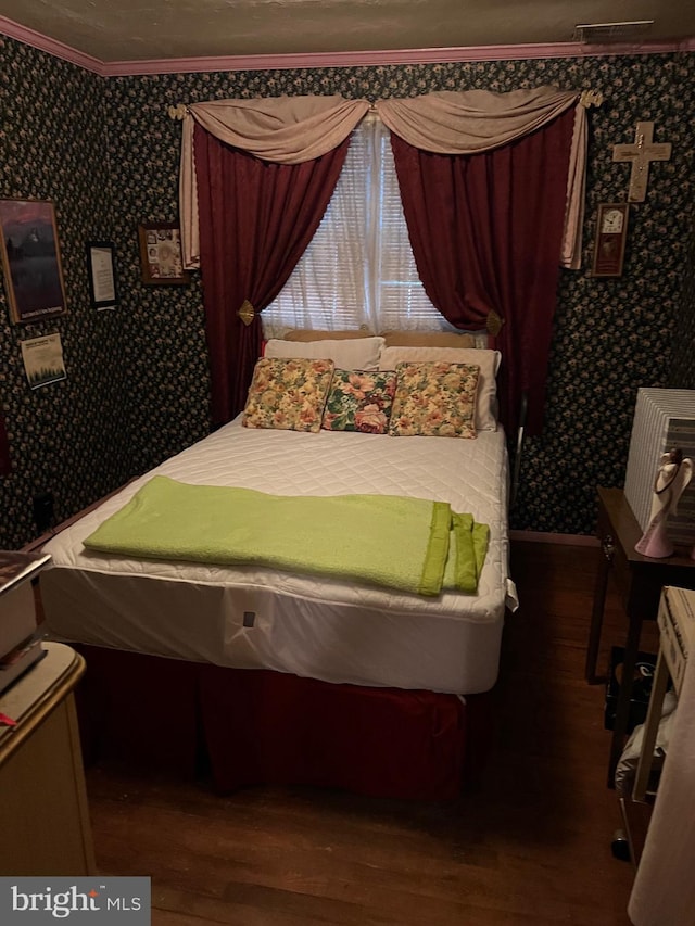 bedroom with dark hardwood / wood-style floors and ornamental molding