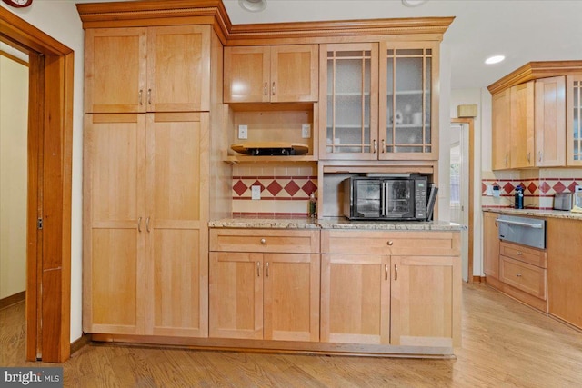 kitchen featuring decorative backsplash, light stone countertops, light wood-type flooring, and light brown cabinetry