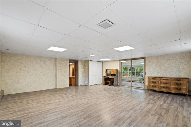 basement with a paneled ceiling and hardwood / wood-style flooring