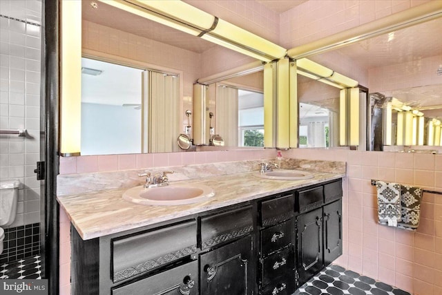 bathroom with backsplash, vanity, tile walls, and toilet